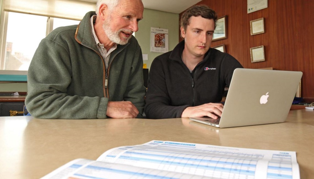 Farmers using the RL on a computer with the booklet on the table